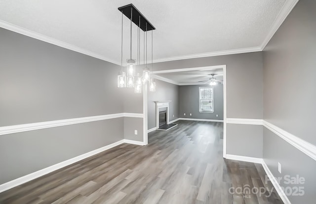 unfurnished living room with a textured ceiling, hardwood / wood-style flooring, ceiling fan, and crown molding