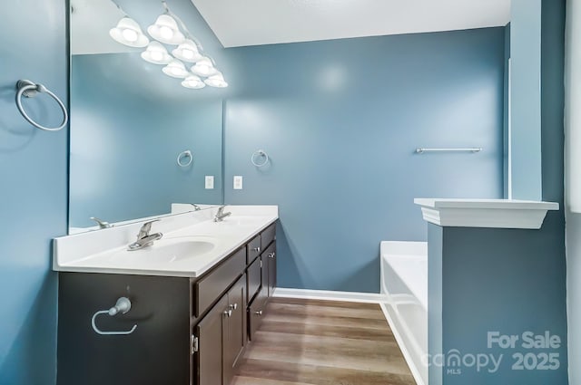 bathroom with a bathing tub, vanity, and hardwood / wood-style flooring