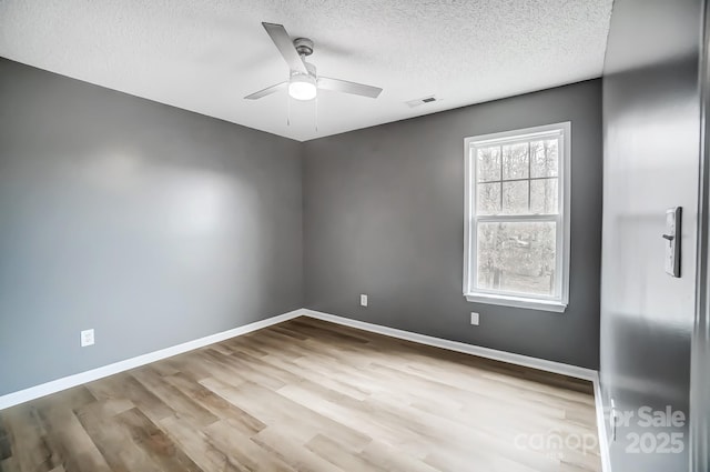 empty room featuring ceiling fan, light hardwood / wood-style floors, and a textured ceiling