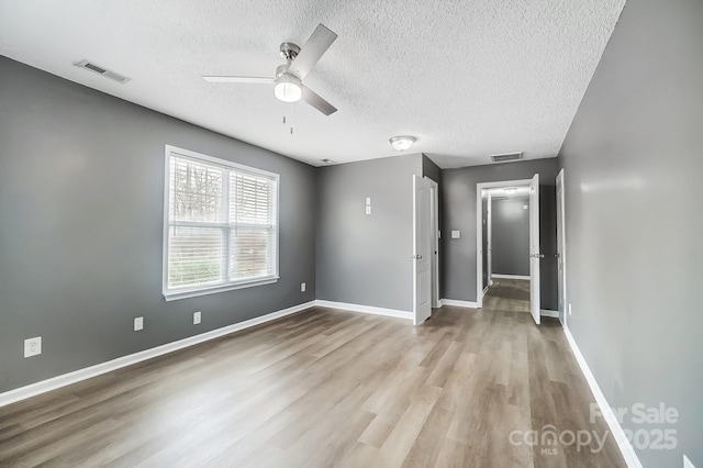 interior space featuring a textured ceiling, light hardwood / wood-style flooring, and ceiling fan