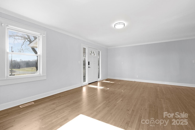 interior space with hardwood / wood-style flooring and ornamental molding