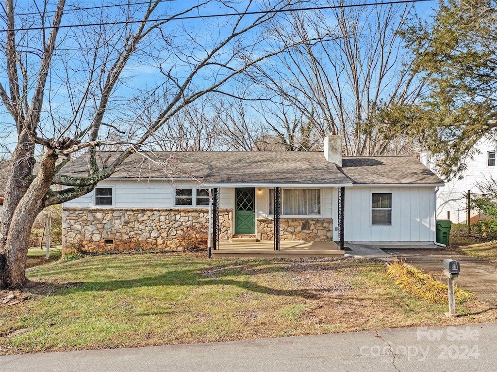 ranch-style home with covered porch and a front yard