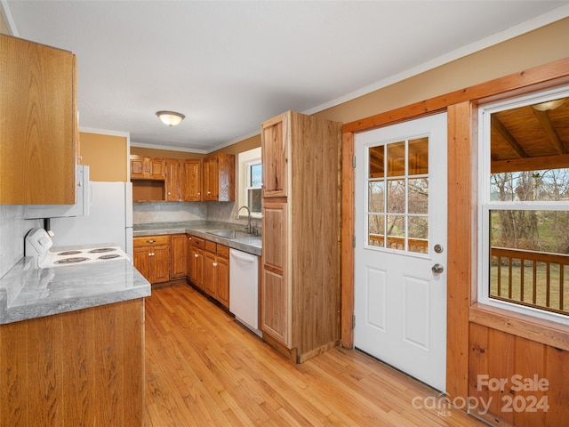 kitchen with white appliances, tasteful backsplash, light hardwood / wood-style flooring, and sink