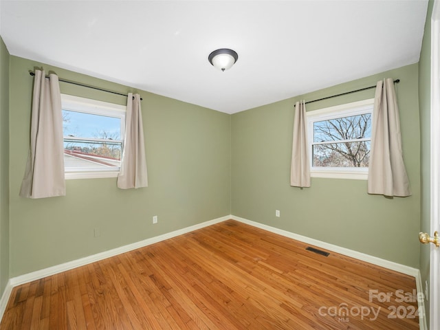 unfurnished room with wood-type flooring