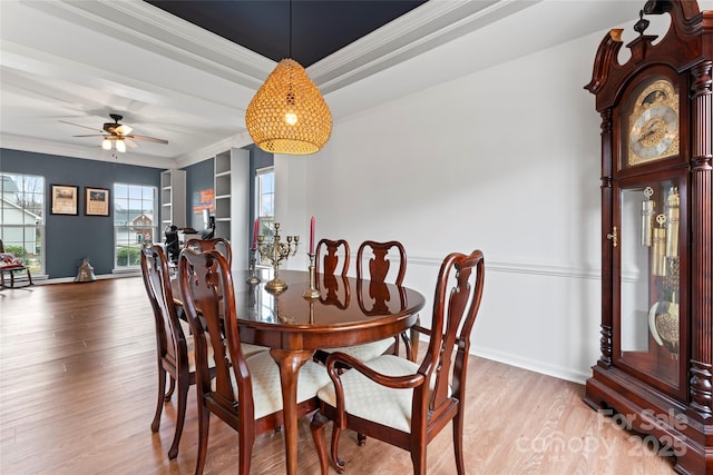 dining room featuring built in shelves, crown molding, ceiling fan, and wood-type flooring