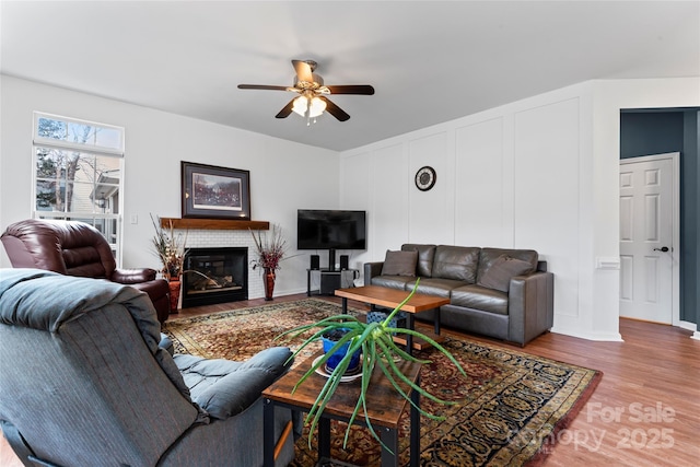 living room with a fireplace, hardwood / wood-style floors, and ceiling fan