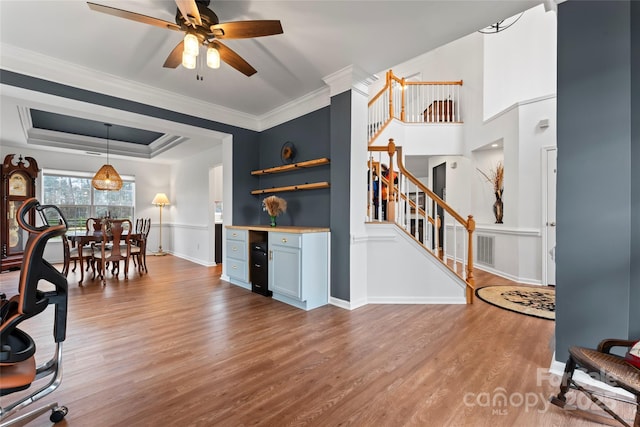 kitchen with ceiling fan, hardwood / wood-style floors, hanging light fixtures, and ornamental molding