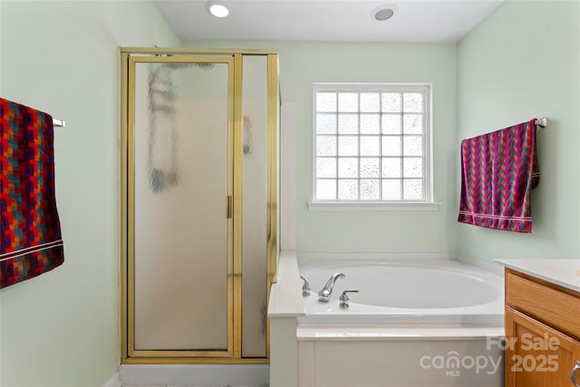 bathroom with vanity and shower with separate bathtub