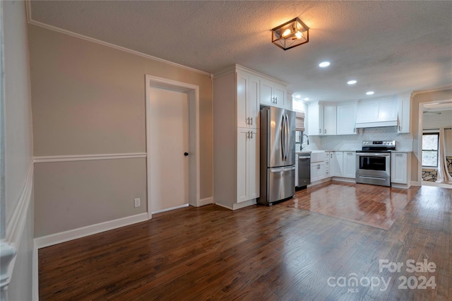 kitchen featuring white cabinets, ornamental molding, stainless steel appliances, and dark wood-type flooring