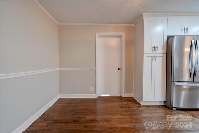 kitchen with a textured ceiling, crown molding, dark hardwood / wood-style floors, white cabinetry, and stainless steel refrigerator