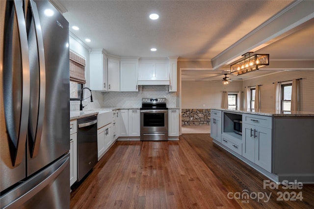 kitchen featuring white cabinets, sink, ceiling fan, ornamental molding, and appliances with stainless steel finishes