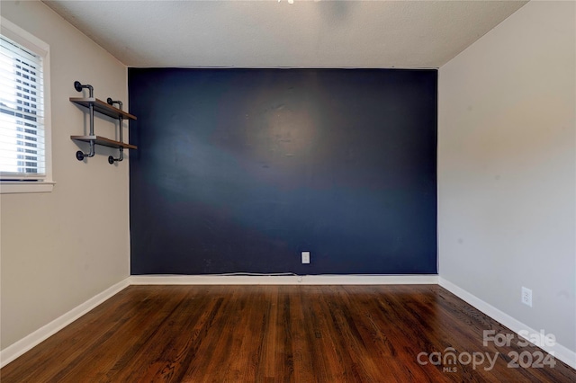 spare room with dark hardwood / wood-style flooring and a textured ceiling