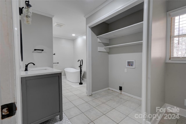 washroom featuring crown molding, sink, light tile patterned flooring, and washer hookup