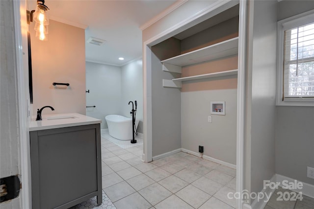 bathroom with vanity, tile patterned floors, a bathtub, and crown molding