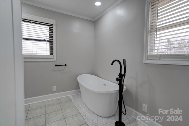 bathroom with a washtub, tile patterned flooring, and ornamental molding