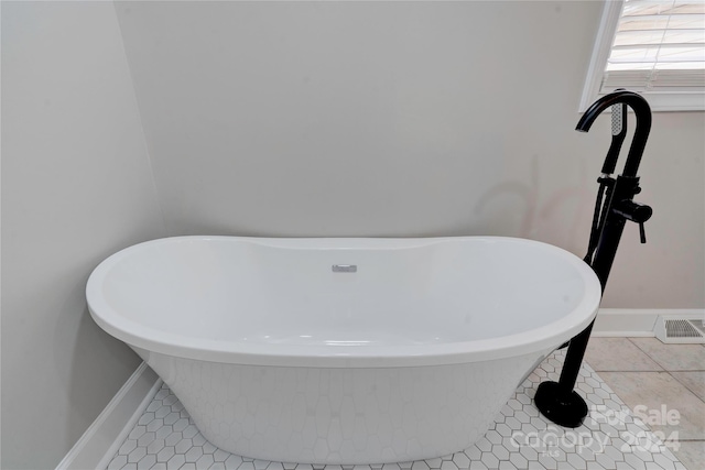 bathroom with tile patterned floors and a washtub