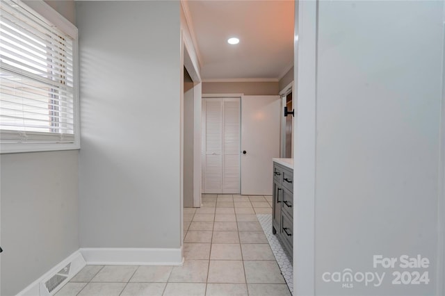 interior space featuring light tile patterned floors and ornamental molding