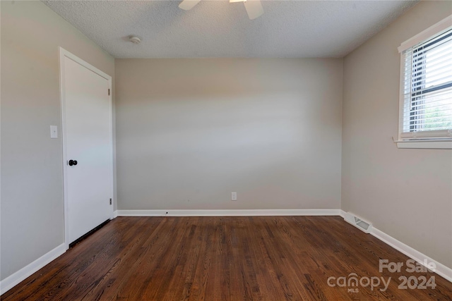 unfurnished room featuring ceiling fan, dark hardwood / wood-style flooring, and a textured ceiling