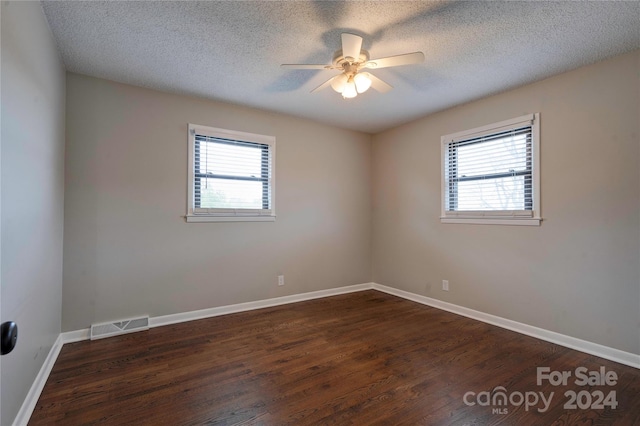 unfurnished room with a textured ceiling, ceiling fan, and dark wood-type flooring