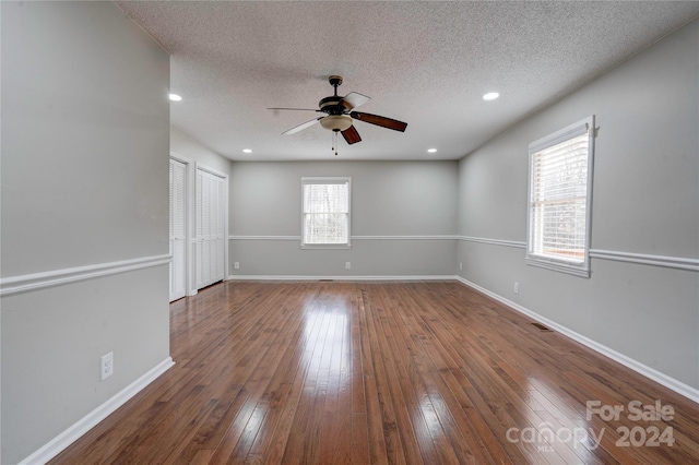 unfurnished room with ceiling fan, a textured ceiling, and hardwood / wood-style flooring