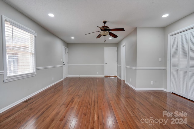 empty room featuring a textured ceiling, ceiling fan, and dark hardwood / wood-style floors