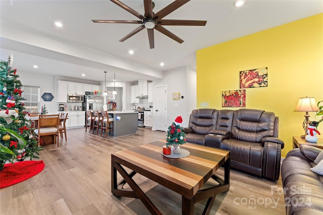 living room featuring light wood-type flooring and ceiling fan