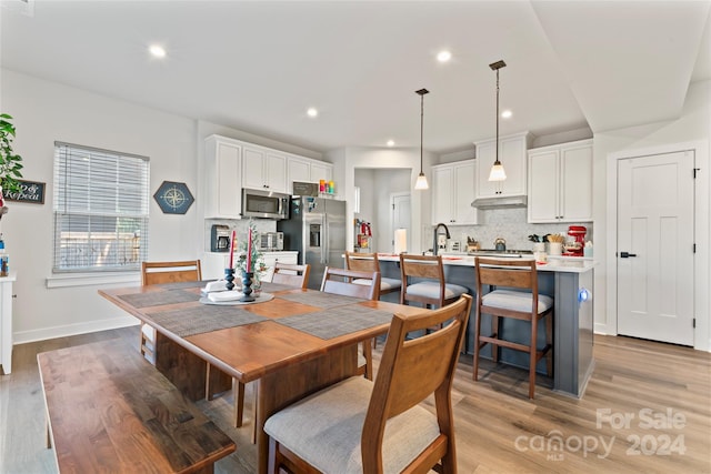 dining room with light hardwood / wood-style floors and sink