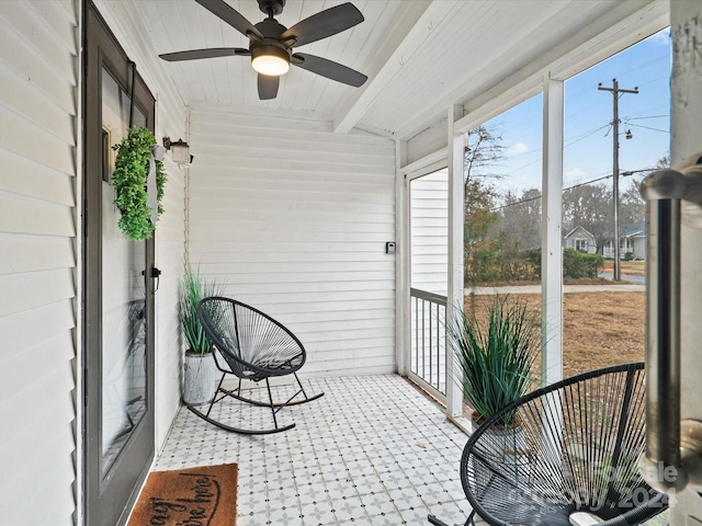 sunroom featuring beam ceiling and ceiling fan