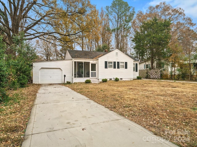 view of front of home featuring a sunroom, a garage, and a front lawn