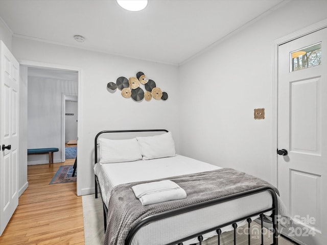 bedroom with hardwood / wood-style flooring and crown molding