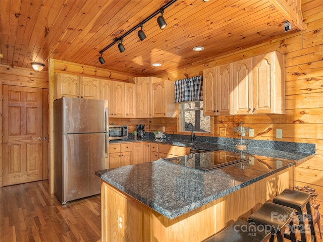 kitchen featuring light brown cabinets, rail lighting, dark hardwood / wood-style floors, wood ceiling, and stainless steel appliances