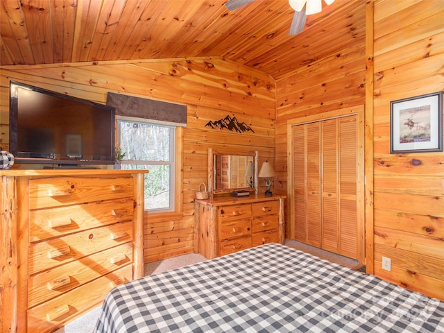 carpeted bedroom featuring wood walls, vaulted ceiling, wood ceiling, and a closet