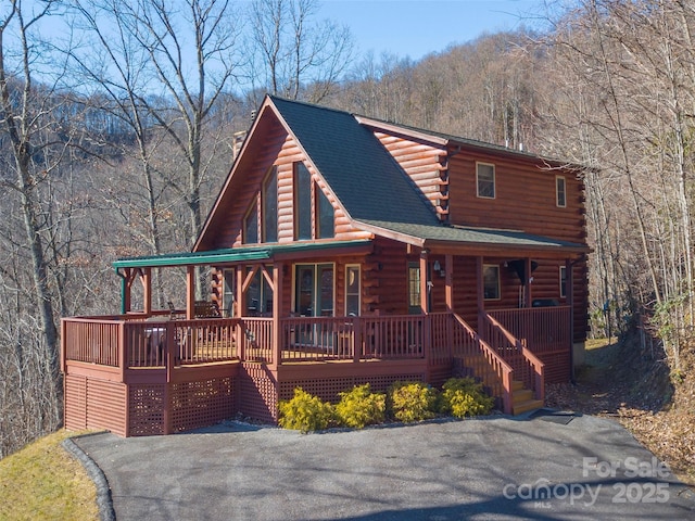 log home featuring covered porch