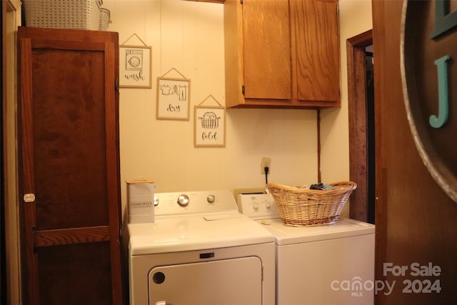 laundry room featuring washing machine and clothes dryer and cabinets