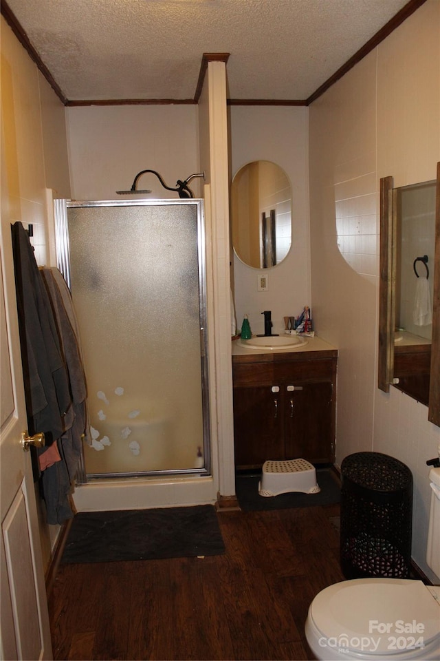 bathroom with hardwood / wood-style floors, vanity, crown molding, a textured ceiling, and an enclosed shower