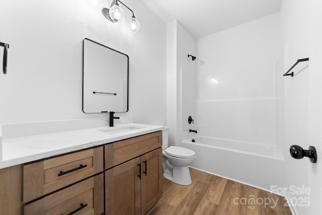 full bath featuring tub / shower combination, toilet, vanity, and wood finished floors