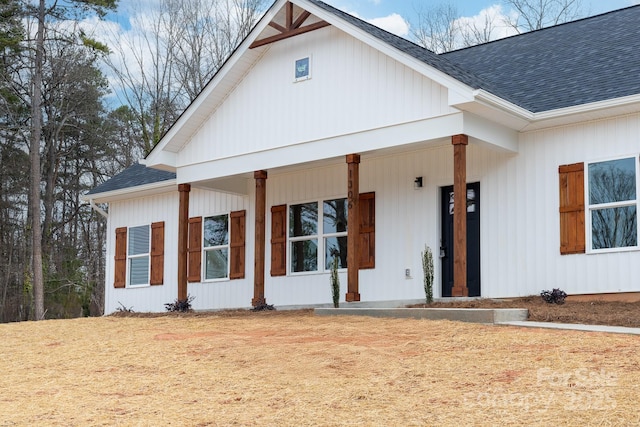 modern farmhouse featuring covered porch and roof with shingles