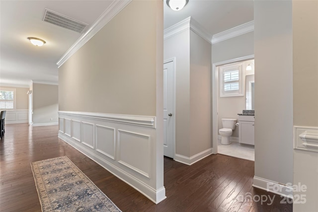 hall with crown molding, dark hardwood / wood-style flooring, and a healthy amount of sunlight