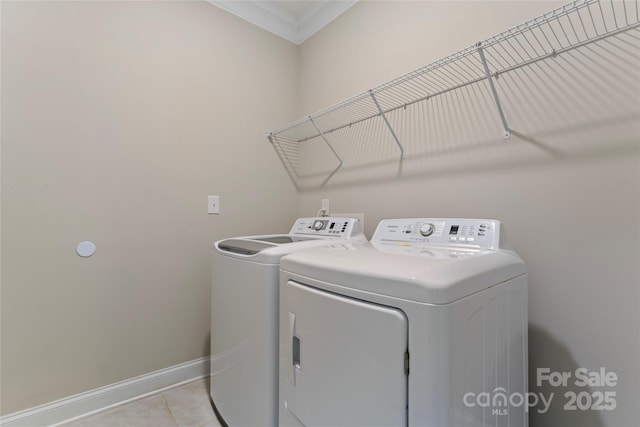 laundry area featuring washing machine and clothes dryer, crown molding, and light tile patterned flooring