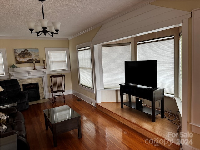 living room with hardwood / wood-style floors, plenty of natural light, crown molding, and an inviting chandelier