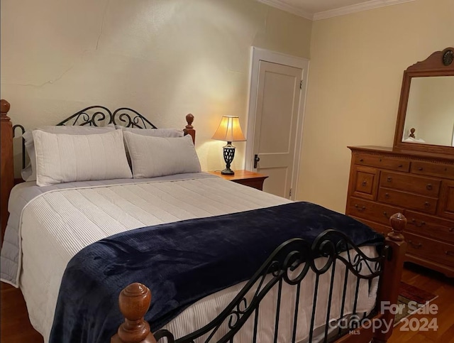 bedroom featuring crown molding and dark hardwood / wood-style flooring