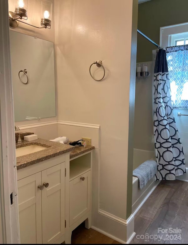 bathroom with vanity, shower / bathtub combination with curtain, and wood-type flooring