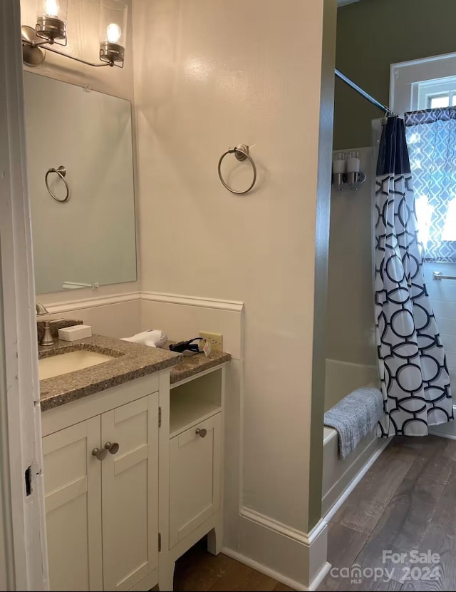 bathroom featuring vanity, wood-type flooring, and shower / tub combo