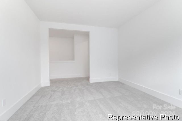 unfurnished room featuring light colored carpet