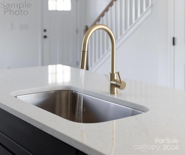 details featuring light stone countertops and sink