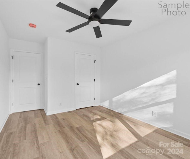 empty room with light hardwood / wood-style floors and ceiling fan