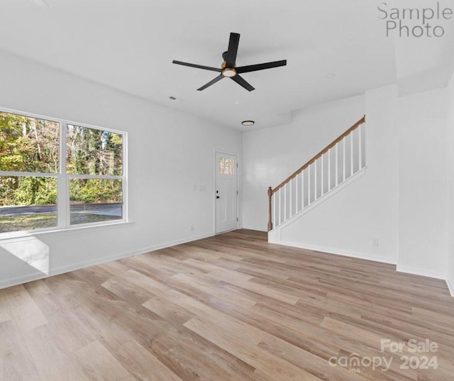 unfurnished living room with light wood-type flooring and ceiling fan