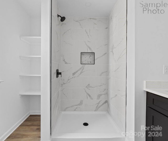 bathroom with vanity, wood-type flooring, and tiled shower