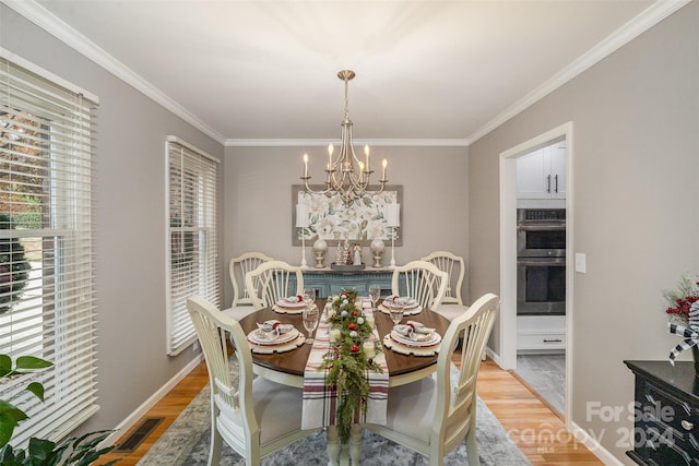 dining room featuring hardwood / wood-style floors, ornamental molding, and a chandelier