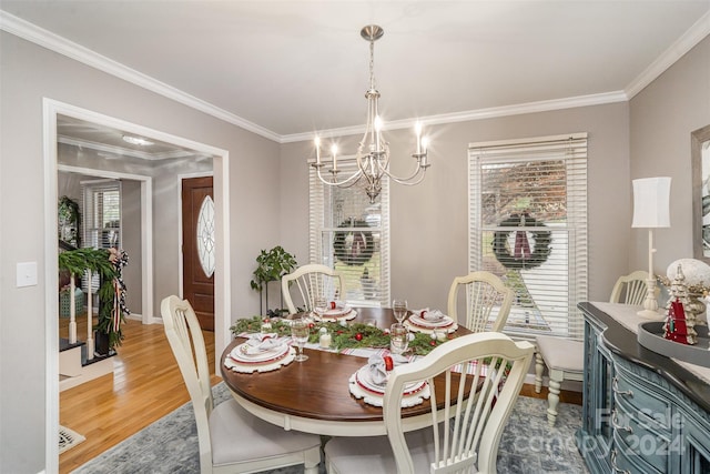 dining area with a chandelier, hardwood / wood-style flooring, and crown molding